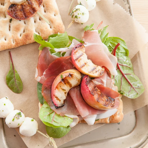 Broodje met gerookte ham en gegrilde perziken — Stockfoto