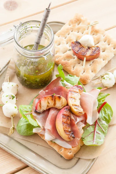 Broodje met gerookte ham en gegrilde perziken — Stockfoto