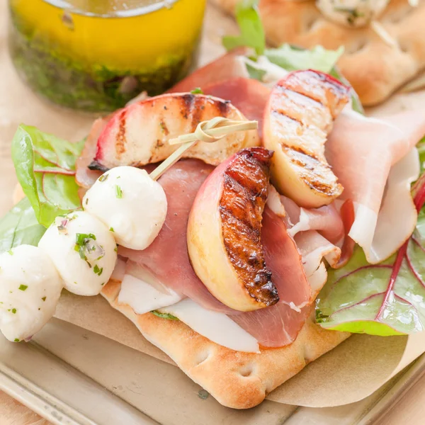 Broodje met gerookte ham en gegrilde perziken — Stockfoto