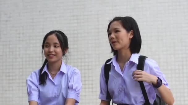 Leuke Aziatische Thaise hoge schoolmeisjes student paar in school uniform praten en chatten met een gelukkig glimlachend gezicht samen op witte achtergrond — Stockvideo