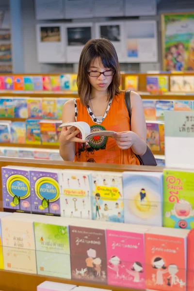 Kvinnan läser bok i öppet buddhismen bibliotek. — Stockfoto