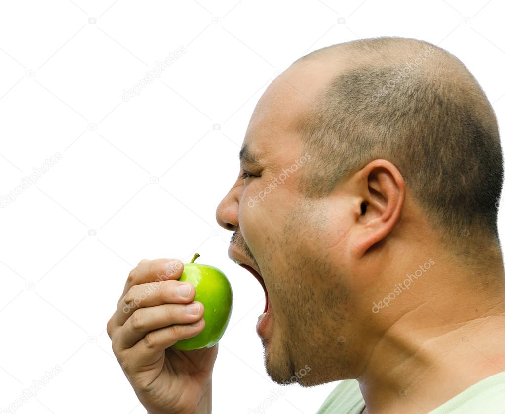 A fat man is forcing himself to eat an apple