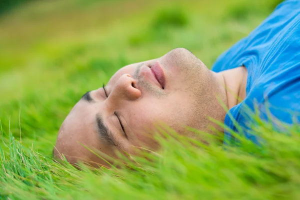 Dicker Mann liegt auf dem grünen Gras, um sich zu rela — Stockfoto