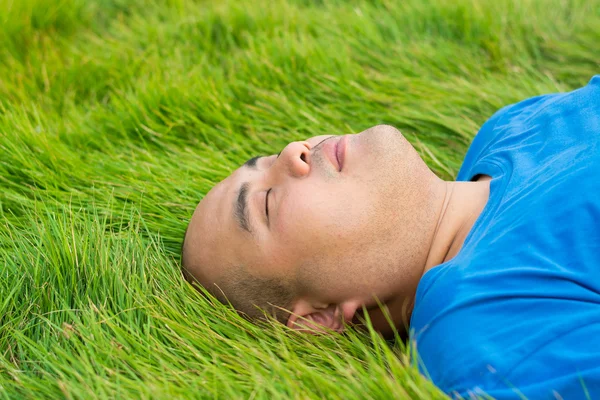 Dicker Mann liegt auf dem grünen Gras, um sich zu rela — Stockfoto