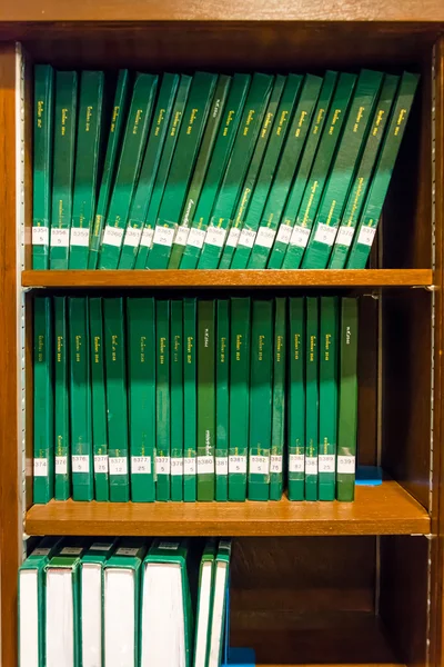 Gröna böcker i bokhyllan i ett bibliotek — Stockfoto