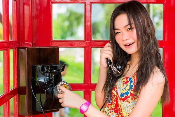 Ázsiai Thai lány beszélgettem egy régi divat telefon, a telefon fülkében a vintage retro divat-stílus. — Stock Fotó