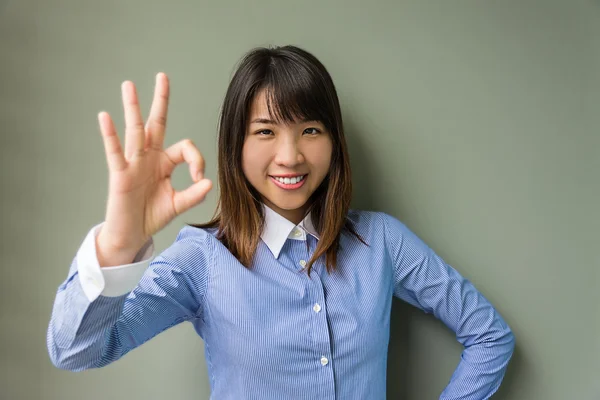 Asiatische thailändische Büromädchen oder Geschäftsfrau präsentiert ein ok Symbol in grauem Grunge isolierten Hintergrund — Stockfoto