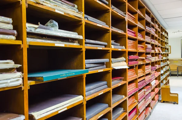 Bücherregale mit alten, abgewetzten Schulbüchern, Dokumenten und historischen Zeugnissen stapeln sich in einer Bibliothek — Stockfoto