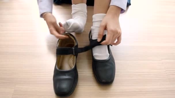 Asian Thai uczennica student w wysoki Szkoła mundur jest noszenie jej czarny skórzany buty w ładny Edukacja Fashion Design na drewnianej podłodze klasie w 1920x1080 jakości HD — Wideo stockowe
