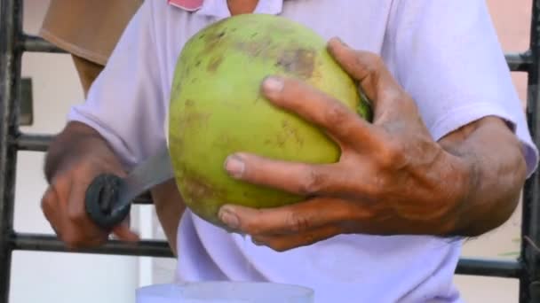 Chef nativo tailandês asiático mostra como beliscar casca de coco fresca para suco de frutas de coco com faca — Vídeo de Stock