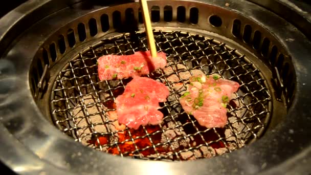 Rebanada de solomillo premium y carne de res ribeye en el tamiz de la parrilla de carbón caliente con picadura de palillo. Es cocina japonesa al estilo barbacoa llamada Yakiniku en el restaurante japonés o coreano . — Vídeo de stock