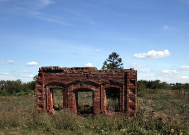 Çimenli tarlası olan eski bir tuğla bina.
