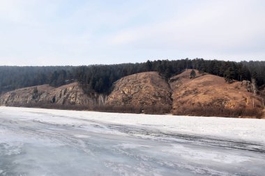 Kayaların yanındaki donmuş nehir. 