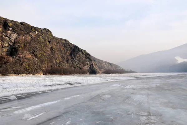 Kayaların yanındaki donmuş nehir. 