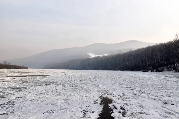 Kayaların yanındaki donmuş nehir. 