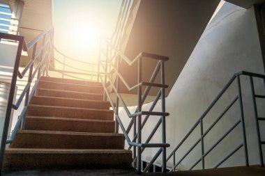 Modern bina sarmal basamağının merdiven çıkışı ve yumuşak sıcak aydınlatma