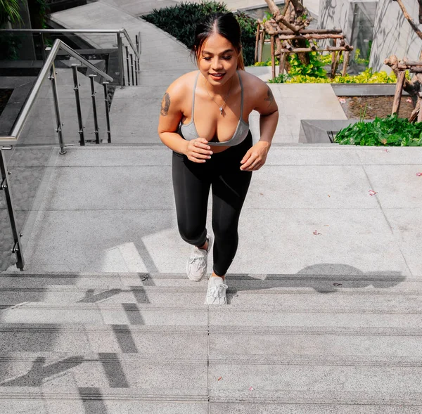 Asyalı sporcu kız dışarıda esneme, yoga ve kalas egzersizi yapıyor. Formda genç Taylandlı kadın sabah antrenman yapıyor..