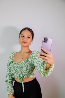 Güzel Asyalı kız akıllı telefonuyla kendi portresini çekiyor. Taylandlı kız selfie 'si.