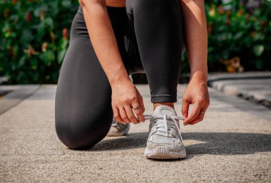 Asyalı sporcu kız dışarıda esneme, yoga ve kalas egzersizi yapıyor. Formda genç Taylandlı kadın sabah antrenman yapıyor..