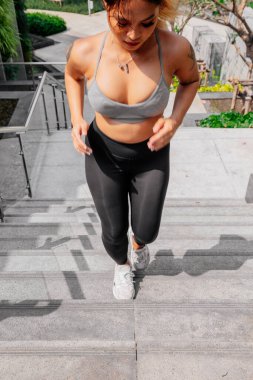 Asyalı sporcu kız dışarıda esneme, yoga ve kalas egzersizi yapıyor. Formda genç Taylandlı kadın sabah antrenman yapıyor..