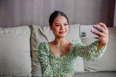 Güzel Asyalı kız akıllı telefonuyla kendi portresini çekiyor. Taylandlı kız selfie 'si.