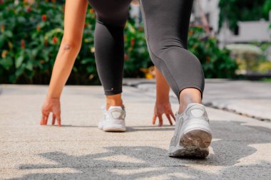 Asyalı sporcu kız dışarıda esneme, yoga ve kalas egzersizi yapıyor. Formda genç Taylandlı kadın sabah antrenman yapıyor..