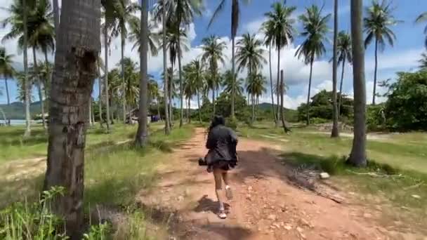 Młoda Azjatka biegająca po plaży z palmami, raj na wyspie koh yao yai, prowincja phuket, Tajlandia — Wideo stockowe