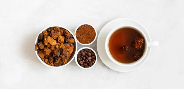 Chaga mushroom drink with coffee and chopped chaga pieces on a white background. New superfood trend. View from above.