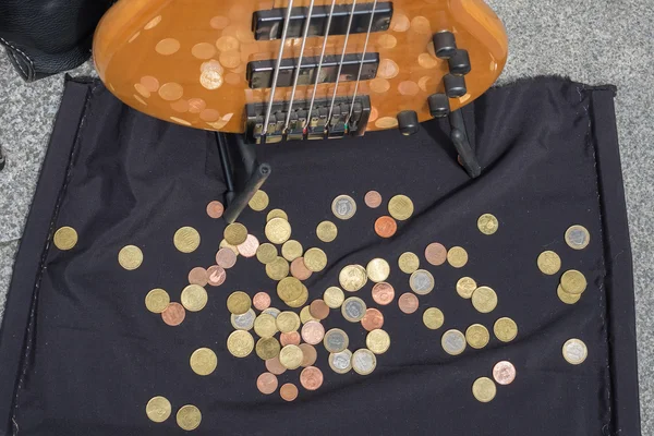 Coins near the guitar of a street musician — Stock Photo, Image