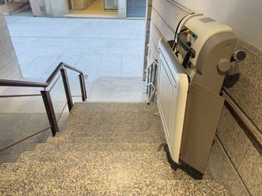 Engelliler için asansör manzarası bir apartmanın ön girişindeki merdivenlerde.