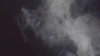 Siyah arkaplanda beyaz duman bulutları, yakın plan, yavaş çekim