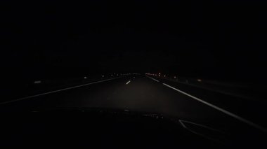 Arabanın içinden gece yolunda farların önünde, ağır çekimde.