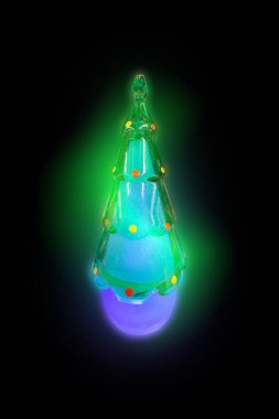 Camdan yapılmış parıldayan bir Noel ağacı. Ağaç ışıl ışıl ve yeşil ve mavi bir renk düzeni var.