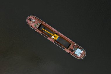 Büyük gemi suda yüzüyor. Gemi sarı ve kırmızı.