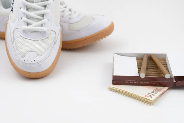 Взуття спортивне, євро та сигарети, концепція здорового способу життя — стокове фото