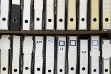 bir raf üzerinde yığılmış belge klasörleri