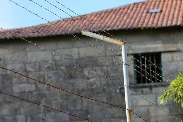 刑務所の塀のクローズ アップの有刺鉄線 — ストック写真