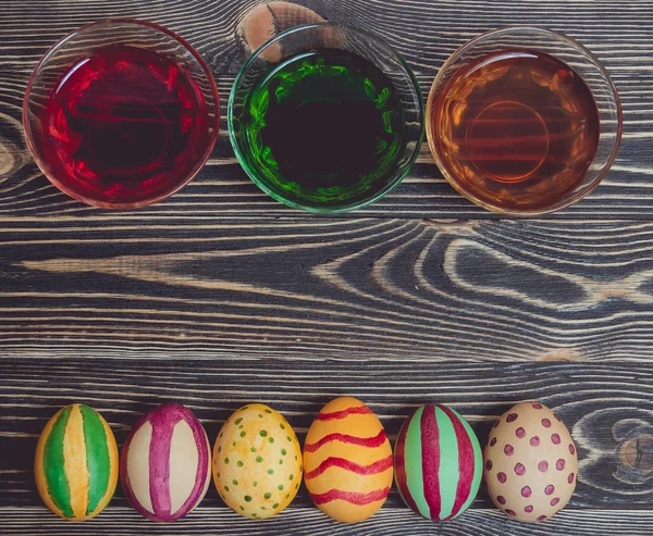 Œufs de Pâques colorés sur fond de panneau de bois — Photo