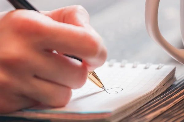 Tjej som skriver med penna i dagbok — Stockfoto