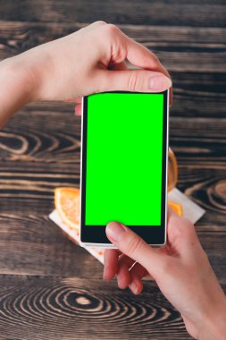 Portakal fotoğrafta eller. Yeşil ekran. Teknoloji kavramı