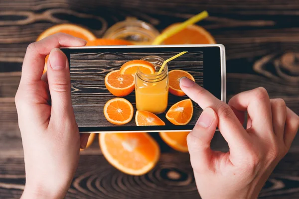 Manos tomando fotos de naranjas. Concepto de tecnología — Foto de Stock