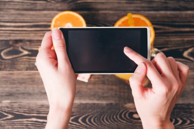 Portakal fotoğrafta eller. Teknoloji kavramı