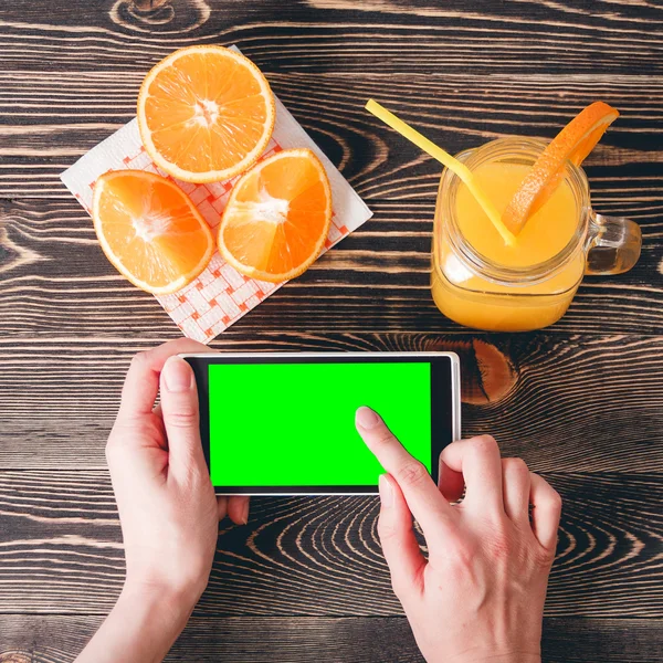 Mujer usando teléfono móvil contra naranjas de frutas. Concepto de tecnología . — Foto de Stock