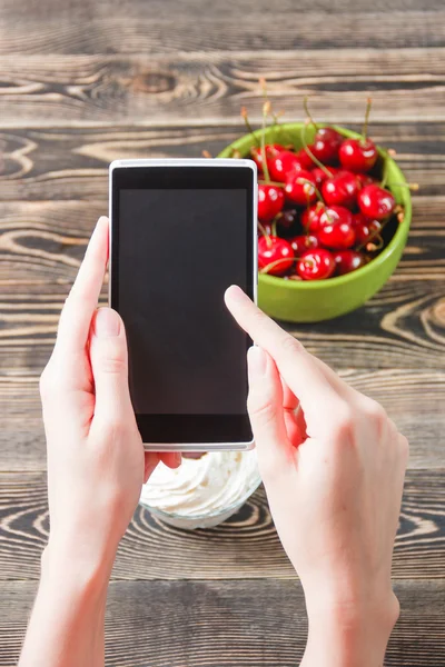 Manos tomando mermelada de cereza con teléfono inteligente — Foto de Stock
