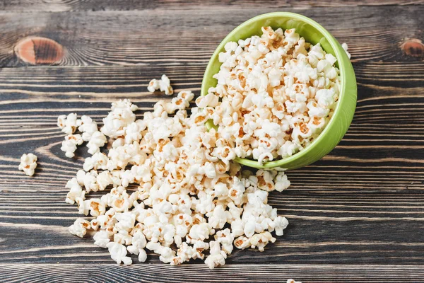 Süßes Karamell-Popcorn in grüner Schüssel auf Holzgrund — Stockfoto