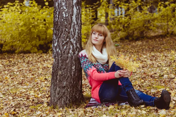 Őszi koncepció - őszi nő ül a parkban — Stock Fotó
