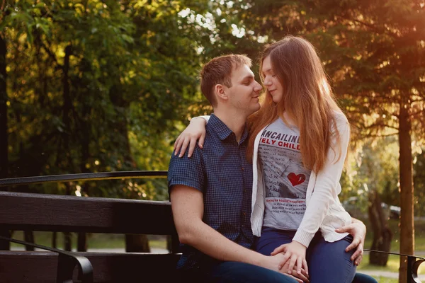 lovely young couple sitting on a seat bench