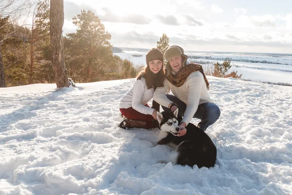 Menina bonita e menino com cão husky na floresta de inverno — Fotografia de Stock