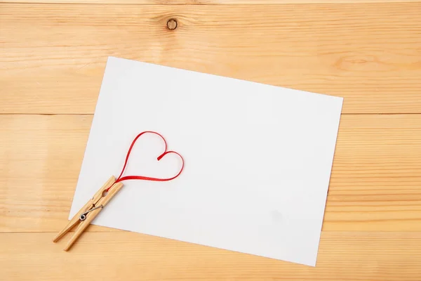 Cartão em branco com coração sobre fundo de madeira — Fotografia de Stock