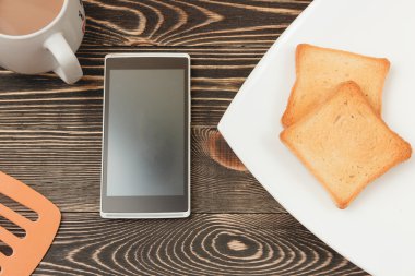 Kahvaltı sahne tost, telefon, ahşap masa Kupası.